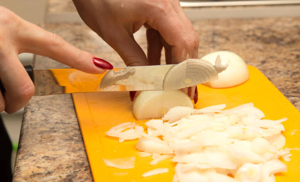 istock Slicing onions with a knife on the board 925367356