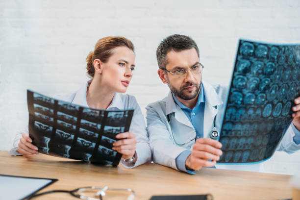 istock serious experienced doctors examining x-ray scans at workplace 925367554