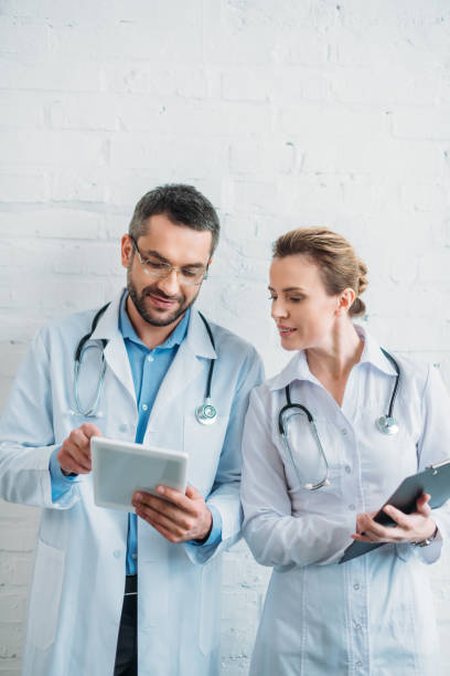 istock doctors working together with tablet and clipboard 925368336