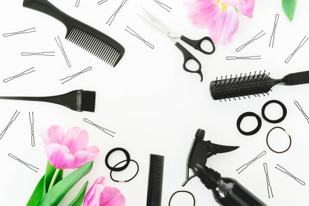 istock Round frame with hairdresser tools - spray, scissors, combs, barrette and tulips on white background. Flat lay, top view 925369334