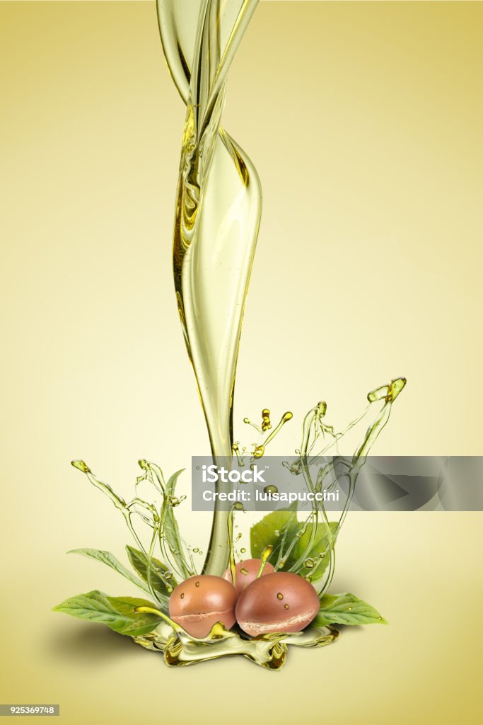 Argan fuits and leave with oil splash on green background Argan fruits and oil splash on green background composite Essential Oil Stock Photo