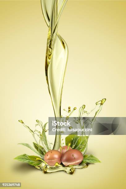 Argan Fuits And Leave With Oil Splash On Green Background Stock Photo - Download Image Now