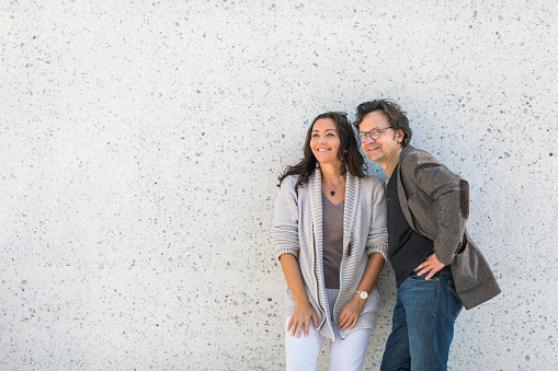 Portrait of a cheerful mature couple against a concrete wall