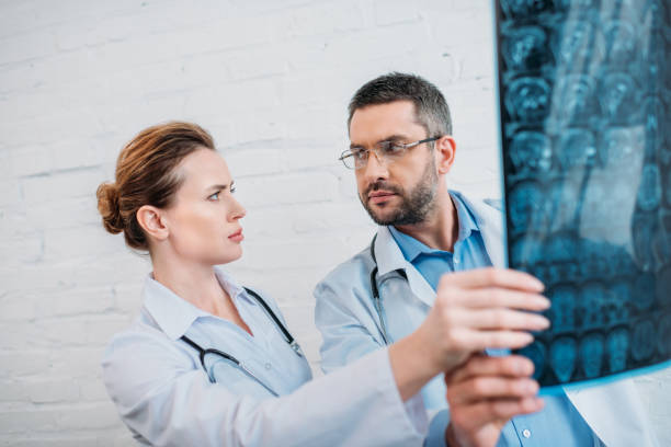 istock bewildered adult doctors examining x-ray scan 925370866