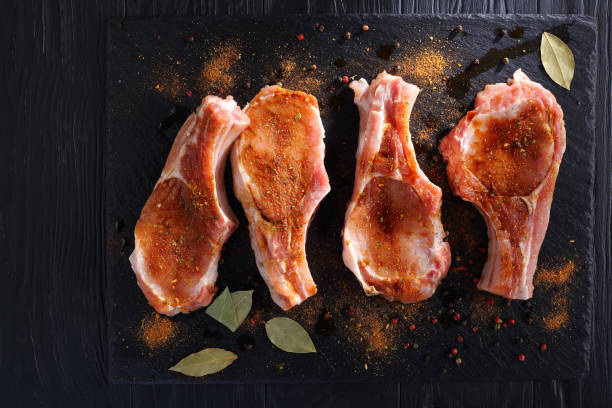 istock raw pork chops seasoned with spices 925371694
