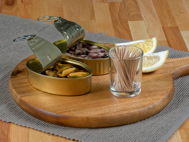 istock Open tin cans of mussels and octopus on a rustic wooden board 925381034