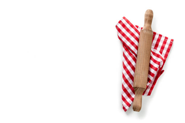 Old wooden rolling pin on checkered napkin isolated on white background. The composition is at the right of an horizontal frame leaving useful copy space for text and /or logo. High key DSRL studio photo taken with Canon EOS 5D Mk II and Canon EF 70-200mm f/2.8L IS II USM Telephoto Zoom Lens