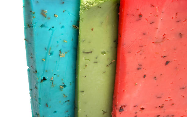Queijo holandês de verde, vermelho e azul. Queijo em um fundo branco. - foto de acervo