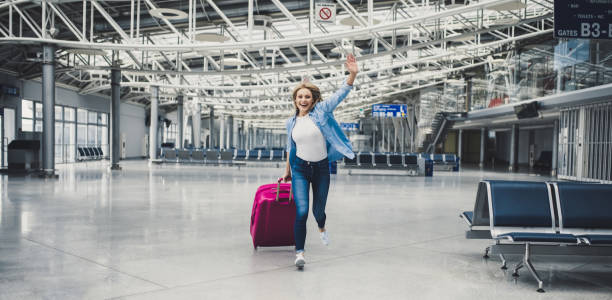 mujer joven en el aeropuerto - arrival airport airport lounge flying fotografías e imágenes de stock