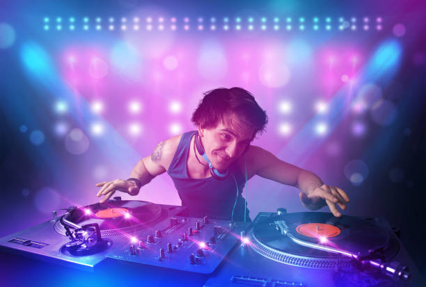 istock Disc jockey mixing music on turntables on stage with lights and stroboscopes 925397490
