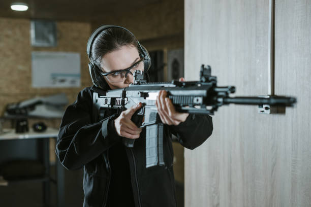 istock girl aiming rifle in shooting range 925413462