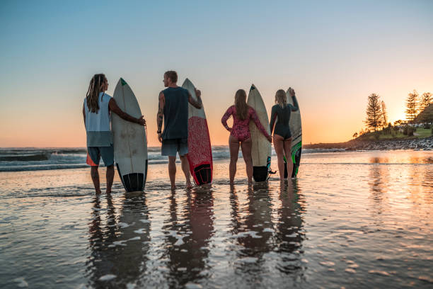 istock Friends stand on the coast and wait for high surfing waves 925416702