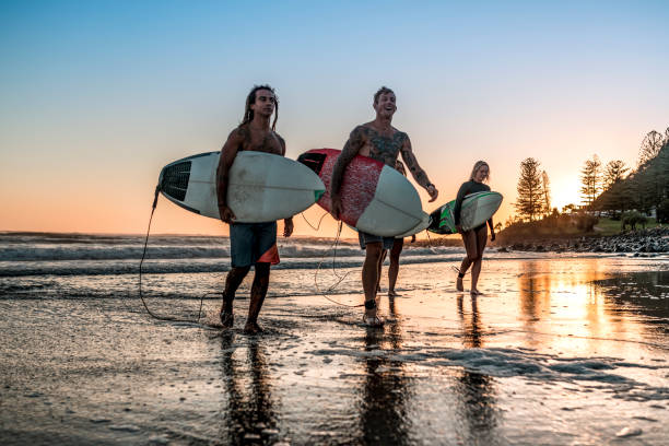 istock Friends walking along the coast with surfboards 925416716