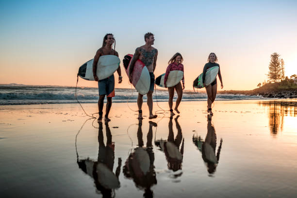 istock Friends walking along the coast with surfboards 925416718