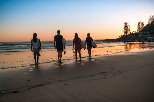 istock Friends stand on the coast and wait for high surfing waves 925416720