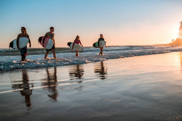 istock Friends walking along the coast with surfboards 925416726