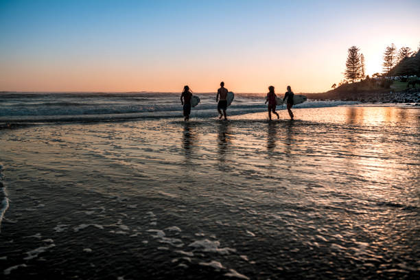 istock Friends running into the sea with surfboards 925416730