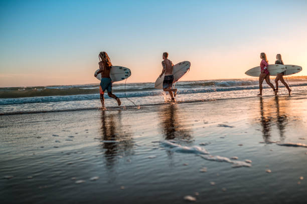istock Friends running into the sea with surfboards 925416738