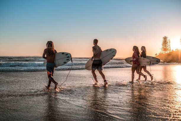 istock Friends running into the sea with surfboards 925416744
