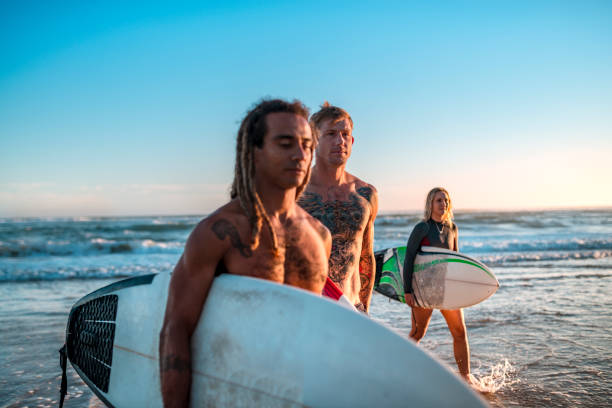 istock Friends walking along the coast with surfboards 925416756