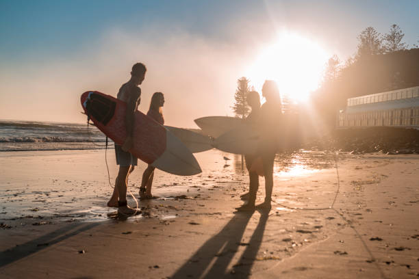 istock Friends stand on the coast and wait for high surfing waves 925416758