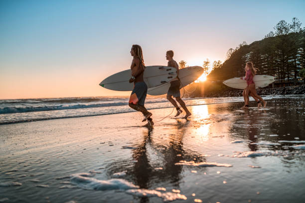 istock Friends running into the sea with surfboards 925416760