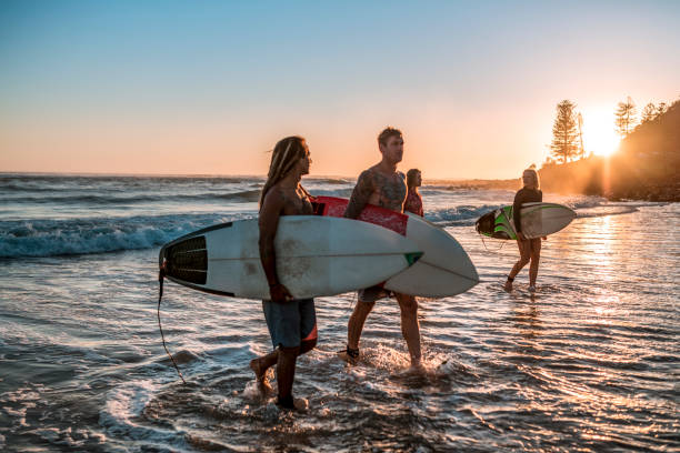amis, marcher le long de la côte avec des planches de surf - exercising wetsuit people expressing positivity photos et images de collection