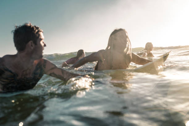 istock Friends enjoying into the sea and learning how to surfboarding 925416816
