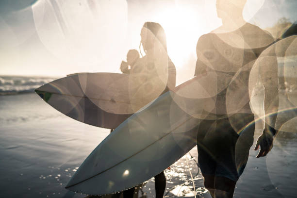 Surfboard riders watch and wait for a wave on a calm Pacific Ocean off Bondi Beach, Sydney on Christmas Day 2022.  Seagulls are visible floating or flying.  This image was taken on a sunny afternoon from the cliffs on the southern end of the beach.
