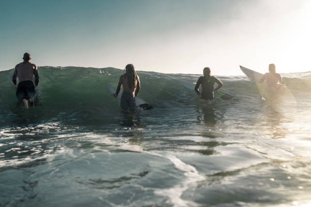 istock Friends enjoying into the sea and learning how to surfboarding 925416854