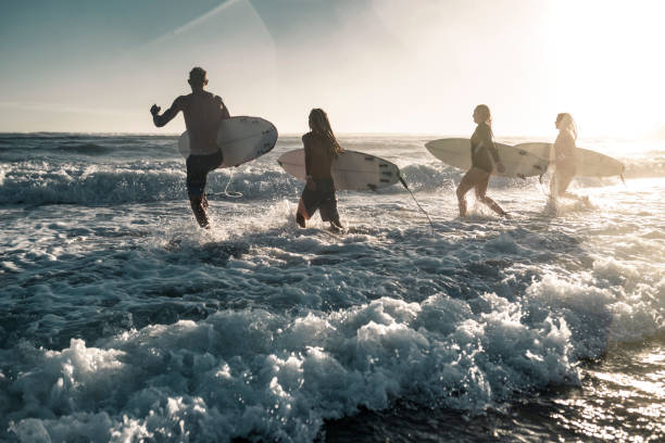 istock Friends running into the sea with surfboards 925416880