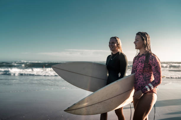 istock Friends walking along the coast with surfboards 925416898