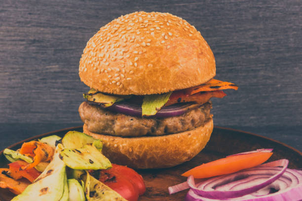 istock Homemade burger with chop and baked vegetables on a dark background 925417082