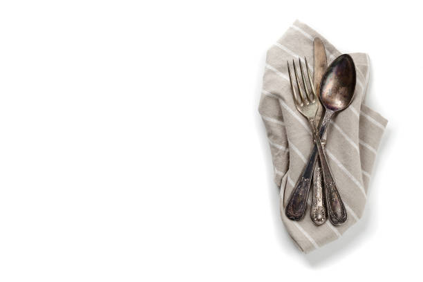 istock Vintage silverware on a textile napkin isolated on white 925417658