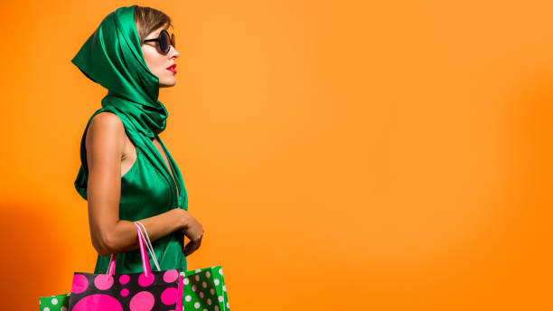 Happy shopping woman with shoping bags Young happy summer shopping woman with shopping bags isolated over bright orange background expense photos stock pictures, royalty-free photos & images