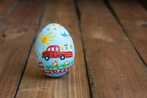 Easter egg with a car on a wooden board