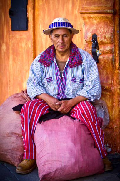 Mayan man sitting in front of house in Antigua, Guatemala. stock photo