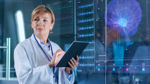 istock Female Scientist Uses Tablet Computer In the Modern Brain Study Laboratory and Monitors EEG Reading and Brain Model Functioning. 925425632