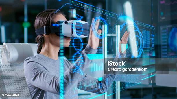 Im Labor Wissenschaftler Interagiert Tragen Virtualrealitykopfhörer In Einem Sessel Sitzend Mit Futuristischen Holograficschnittstelle Neurologische Daten Angezeigt Moderne Brainstudie Neurologische Forschungszentrum Stockfoto und mehr Bilder von Virtual-Reality-Simulator