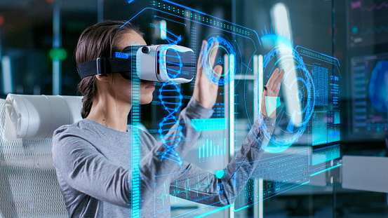 In Laboratory Scientist Wearing Virtual Reality Headset Sitting in a Chair Interacts with Futuristic Holografic Interface, Showing Neurological Data. Modern Brain Study/ Neurological Research Center.