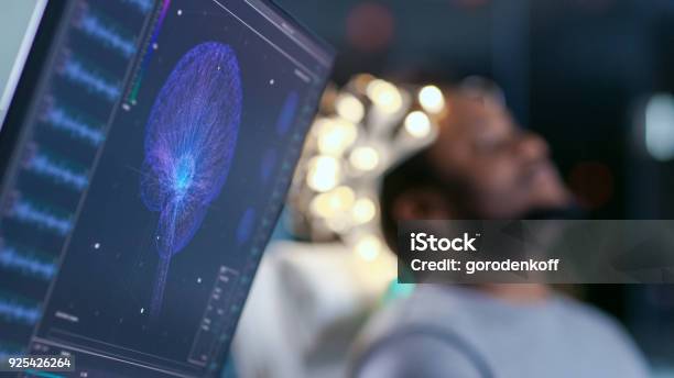 Monitors Show Eeg Reading And Graphical Brain Model In The Background Laboratory Man Wearing Brainwave Scanning Headset Sits In A Chair With Closed Eyes In The Modern Brain Study Research Laboratory Stock Photo - Download Image Now