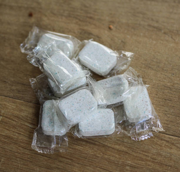 istock Stack of white dishwasher cubes in plastic on wooden background 925428578