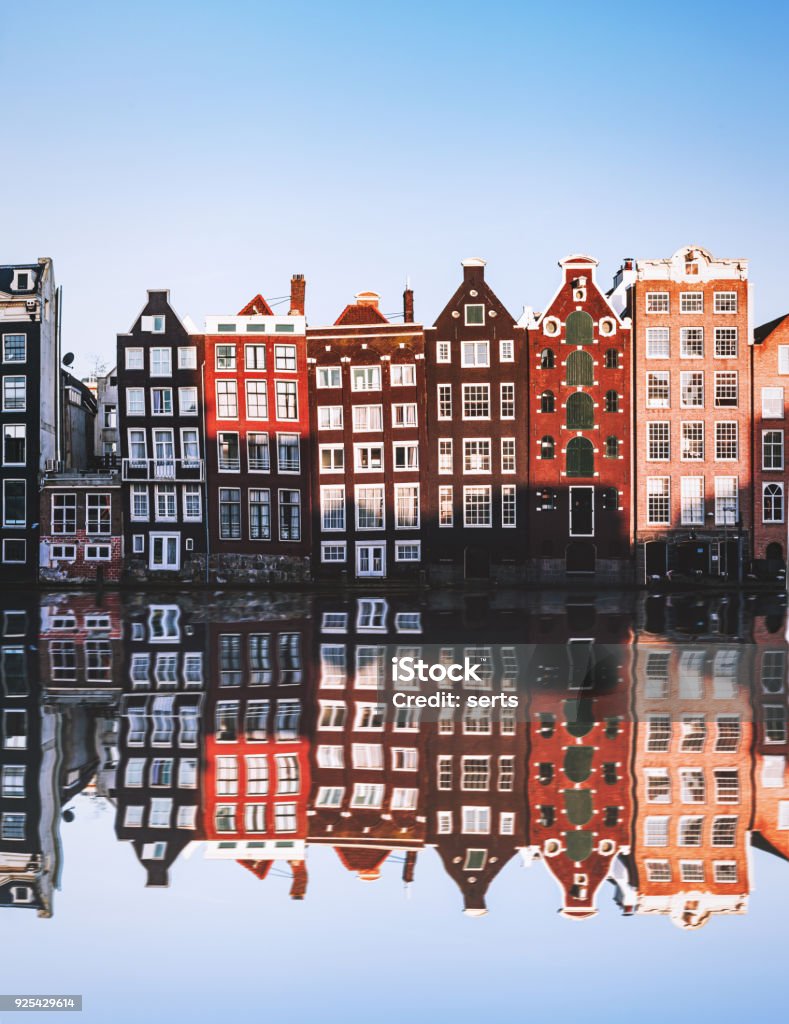 Typical Dutch Houses reflections at night on the water of the canal Amsterdam City Scene with many typical dutch houses in row and their reflection effect in the canal. Old 17th and 18th century brick houses along a canal in center of Amsterdam, Netherlands. Amsterdam Stock Photo