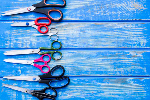 istock A lot of scissors on a blue wooden table. 925436724