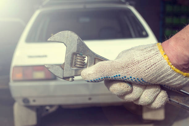 istock Hand with a key on a white car background. 925439728