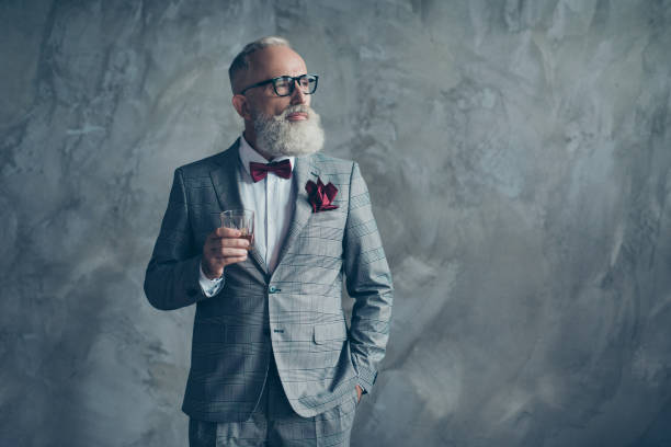 stile di vita lussuoso e beneso. ritratto di rispettabile pianificazione fiduciosa bella brutale maschile a scacchi grigio tux vinoso bevanda potabile isolata sullo sfondo - pocket suit glasses jacket foto e immagini stock