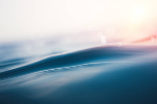 meer welle bei sonnenuntergang - flowing blue rippled environment stock-fotos und bilder