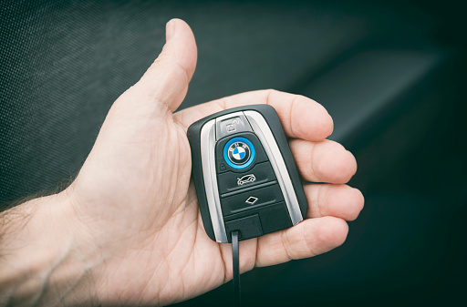 Istanbul, TUrkey - May 17, 2016: Hand holding the wireless key of BMW i3,  a B-class, high-roof hatchback manufactured and marketed by BMW with an electric powertrain using rear wheel drive.
