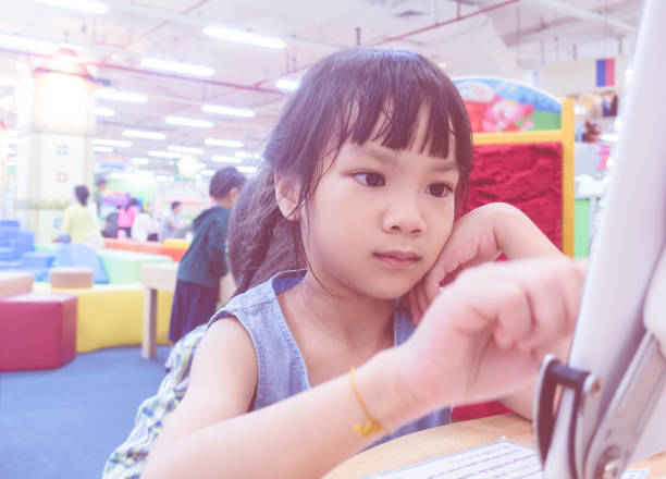 istock Kid using tablet on classroom table, focusing on the hand and tablet 925450728