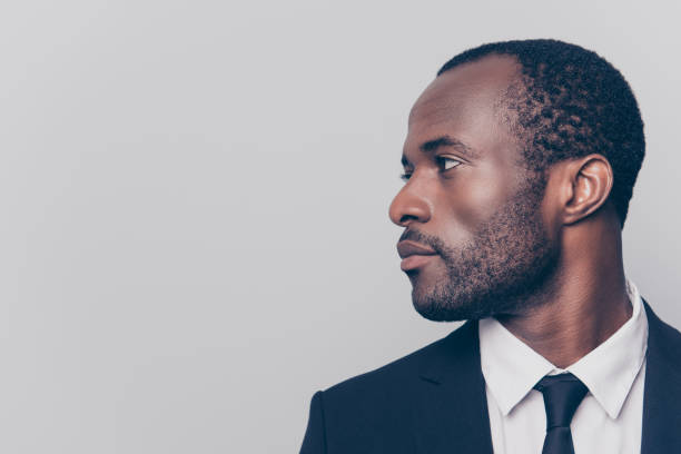 istock Half-turned side profile close up view portrait of handsome virile masculine attractive confident smart intelligent clever african man looking aside weairng smartsuit isolated on gray background 925465708